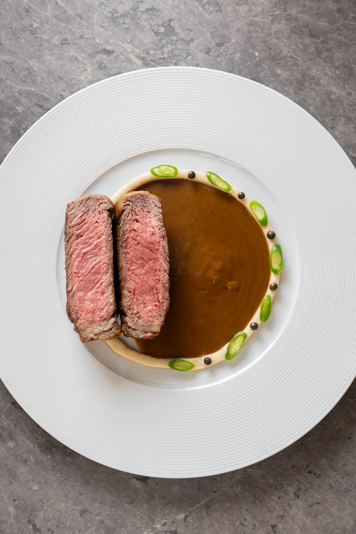 Centro de ojo de bife con pimienta verde y cebolla de verdeo